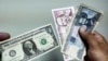 Un hombre muestra dólares estadounidenses y pesos cubanos. (YAMIL LAGE AFP/Archivo)
