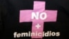 Una mujer sostiene una camisa con la frase "No mas Feminicidios "