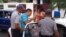 En esta foto de archivo la opositora cubana Ailer González es detenida por tres policías. Social Media