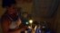 Una mujer prepara unos platos de comida en la cocina, iluminada con velas, en un apagón en el barrio de Alamar