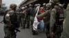 Militares retiran a una mujer que bloqueaba el paso de una tanqueta de la Guardia Nacional durante una manifestación.