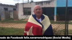 Félix Navarro posa arropado por una bandera cubana. 