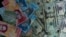 Billetes venezolanos y dólares estadounidenses.