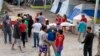Migrantes en un campamento temporal a las afueras de El Puente Nuevo, en Matamoros, México. (Denise Cathey/The Brownsville Herald vía AP)