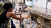 Una mujer cuelga ropa en una tendedera cerca de un montón de basura en la calle, en La Habana, Cuba, 31 de agosto de 2024. REUTERS/Norlys Perez