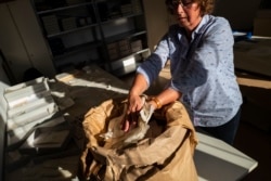 Una empleada del gobierno alemán tras la caída del Muro de Berlín recupera documentos de bolsas marcadas “para destruir” en lo que fuera la sede de la STASI (Foto: John MacDougall/AFP).