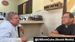 El jefe de la misión diplomática de EEUU en La Habana Mike Hammer conversa con el sacerdote católico cubano Alberto Reyes, en Esmeralda, Camagüey. (X/@USEmbCuba)